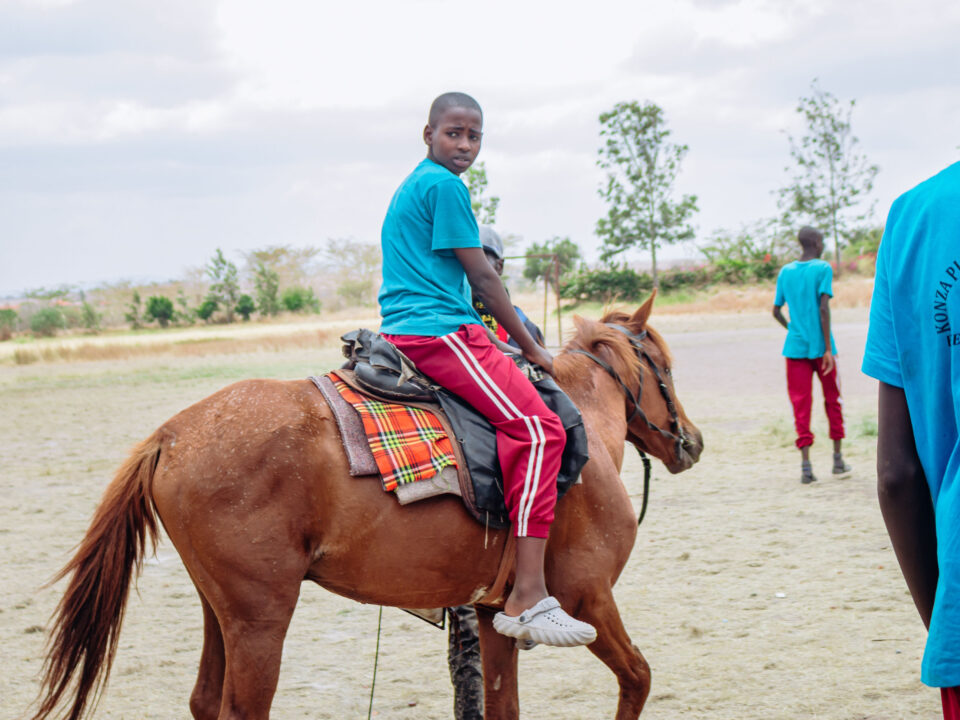 A student riding a horse in a school fun day