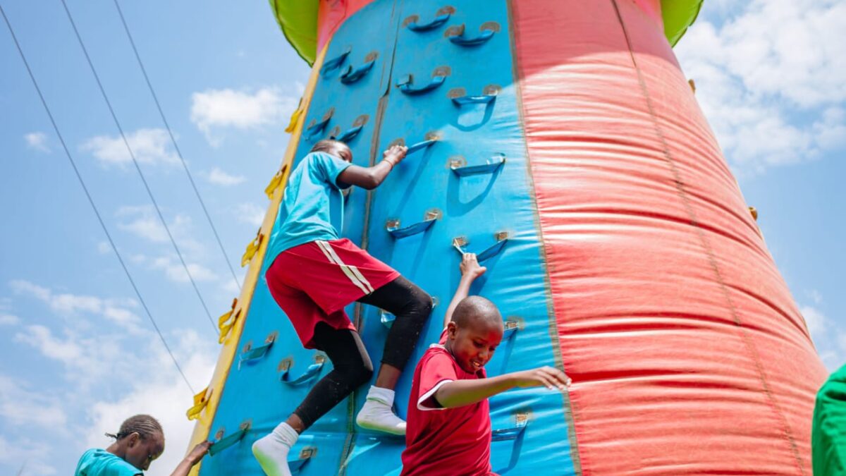 kids climbing an inflatable climbing wall in a fun day
