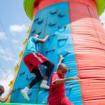 kids climbing an inflatable climbing wall in a fun day