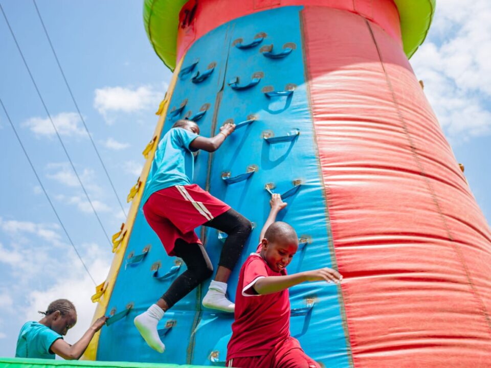kids climbing an inflatable climbing wall in a fun day