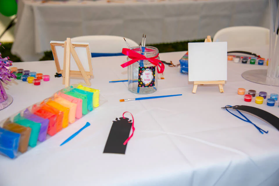 A table with art materials for art and craft activities for a birthday party